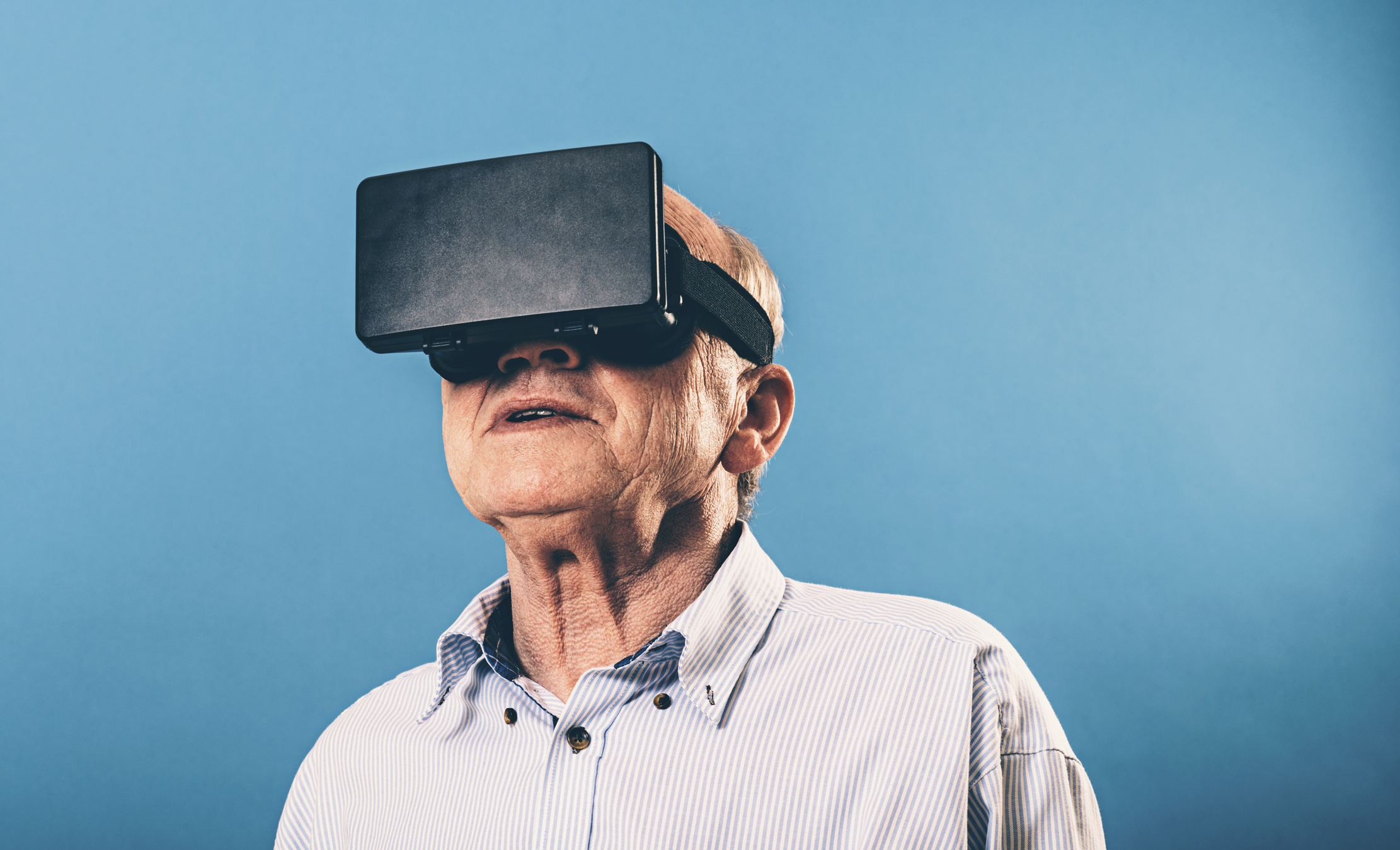 Senior man watches content on a pair of VR glasses (virtual reality).