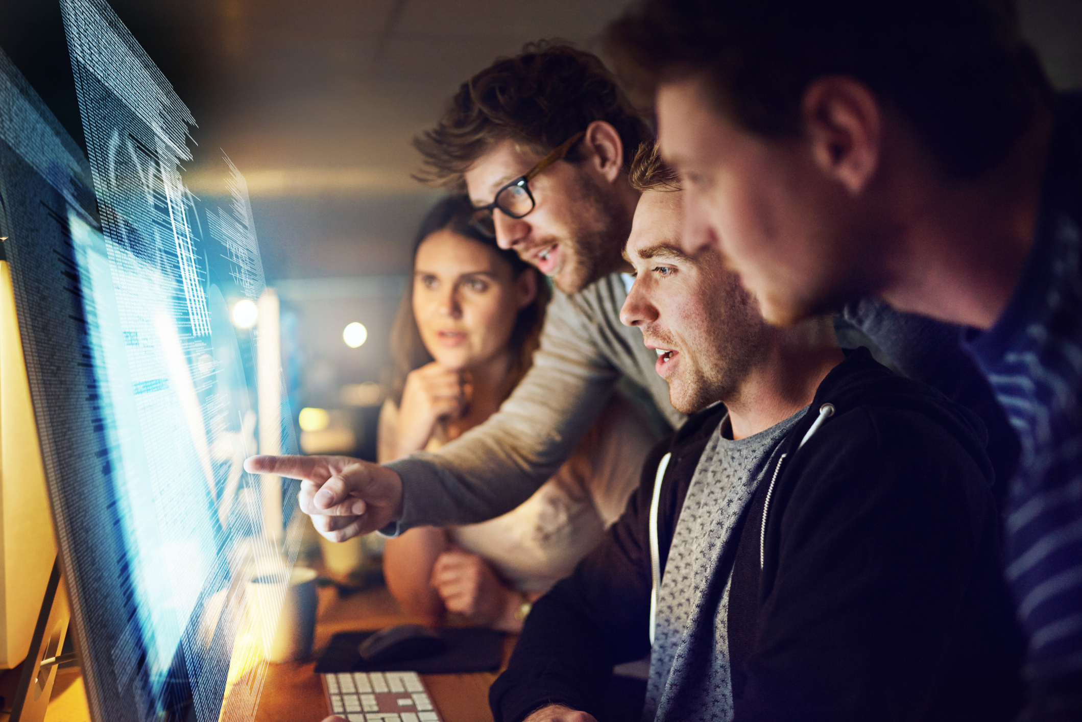 Shot of a group of programmers working on a computer code at night