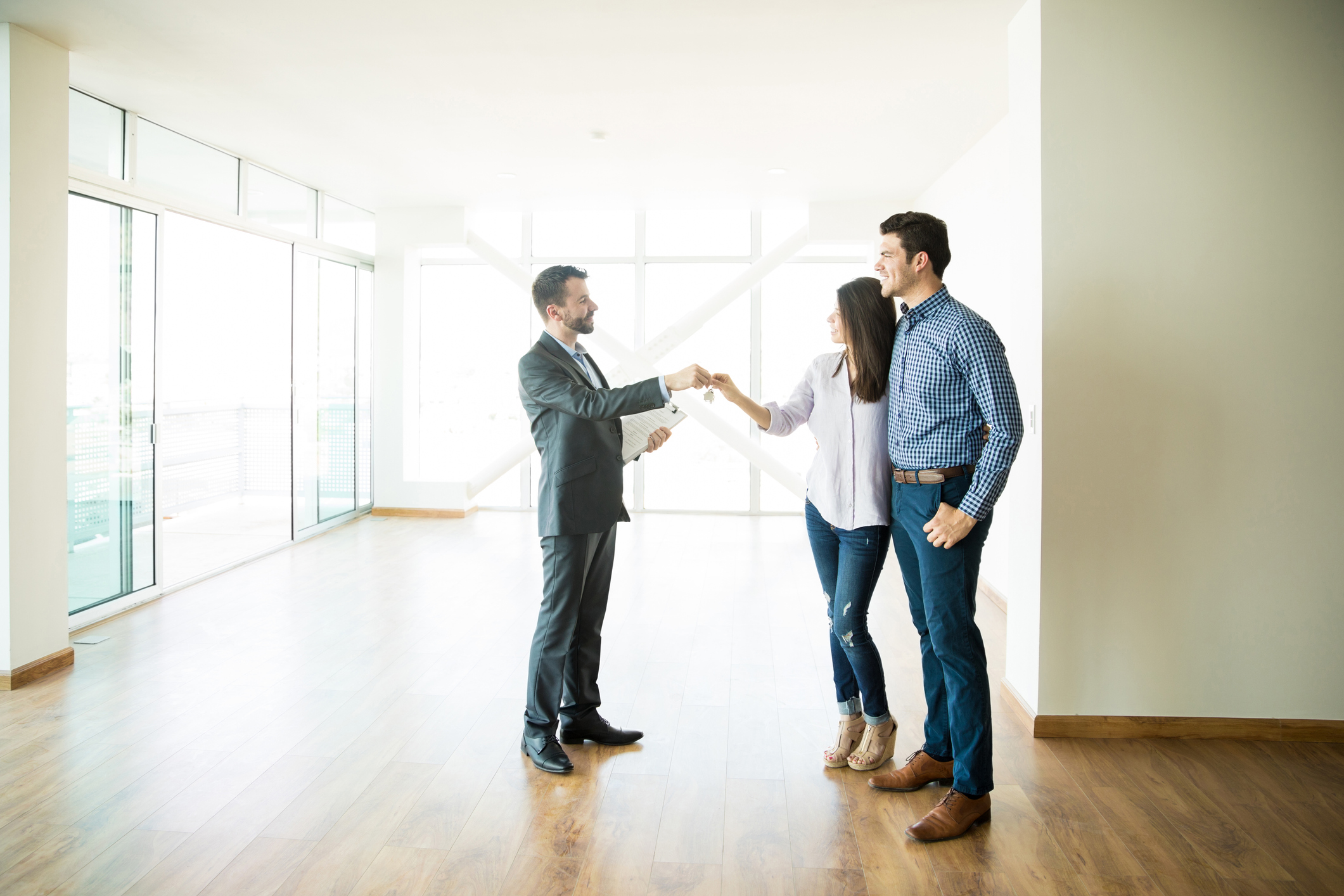 Happy mid adult couple getting keys from realtor of their new home