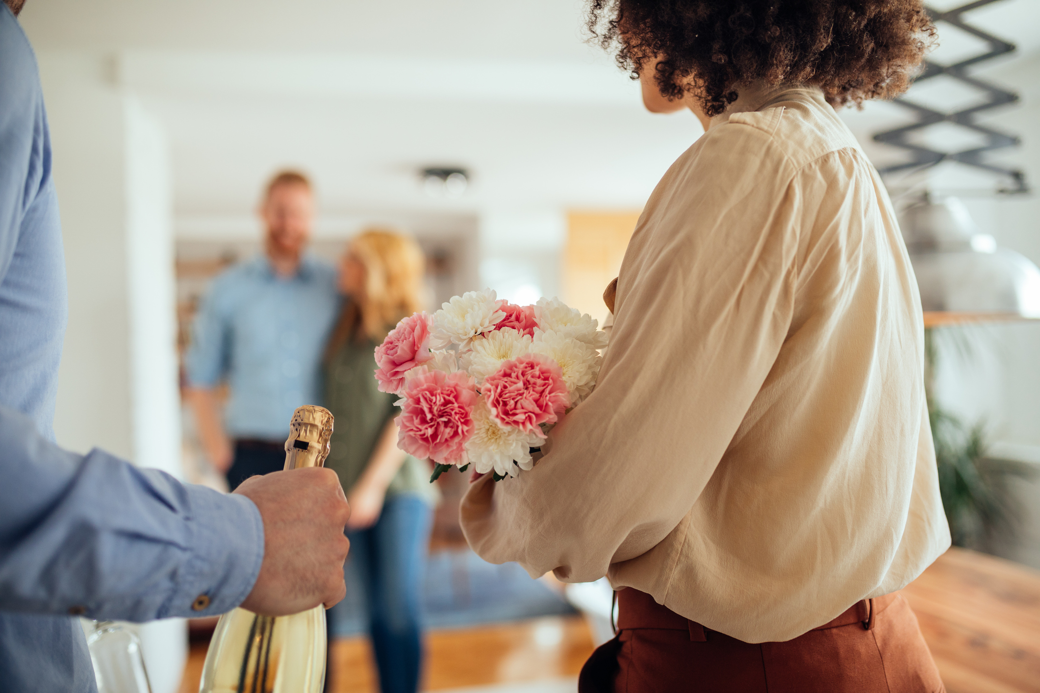 Cropped shot of a young couple visiting friends in their new home. Selective focus.