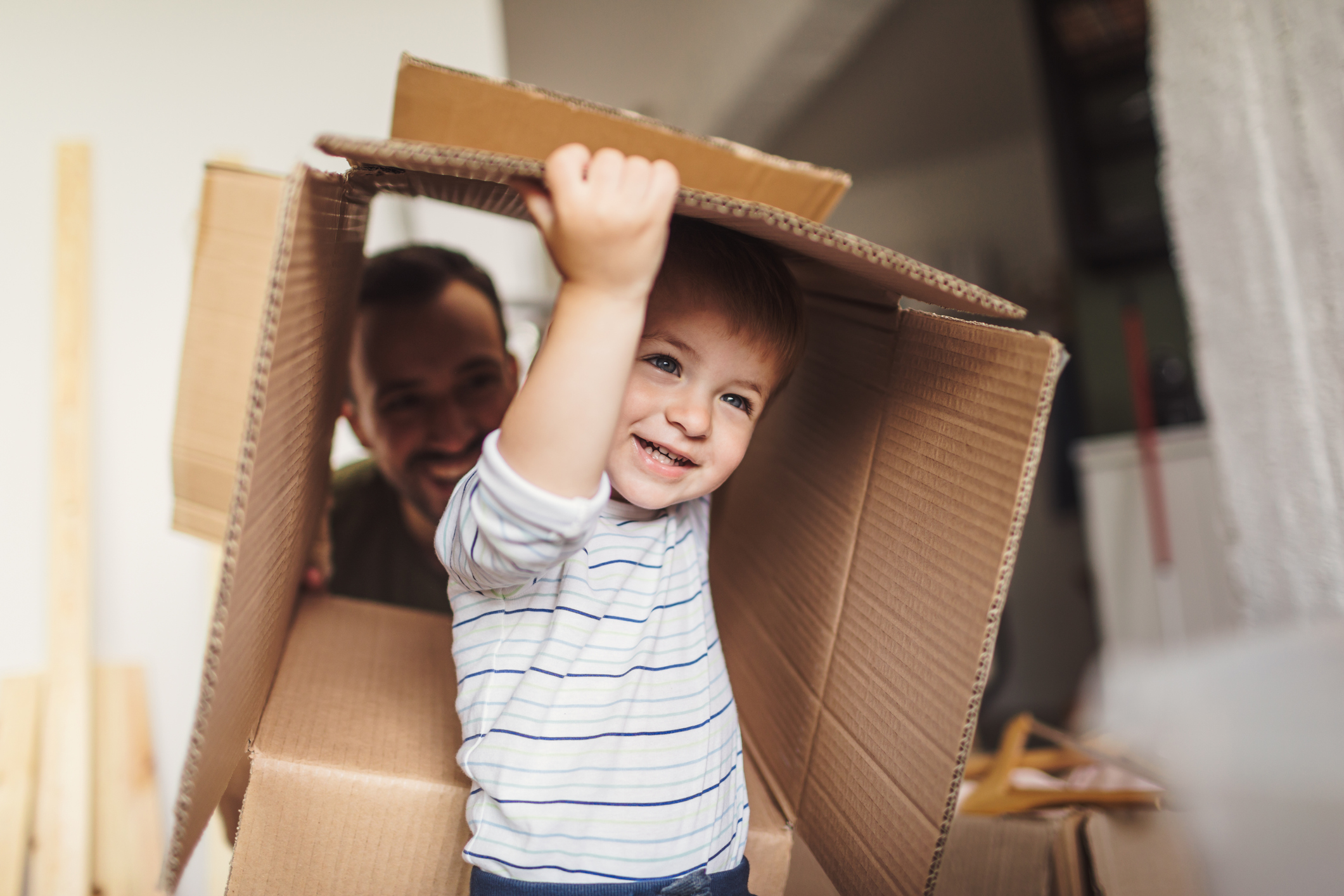 Photo of a little cheerful boy moving into his new family home