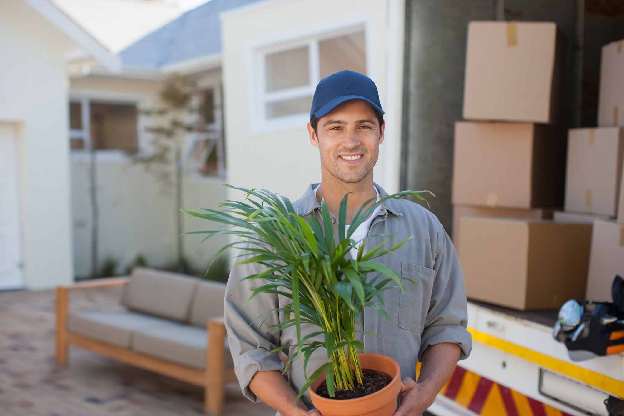 Smiling man carrying Flowerpot moving van