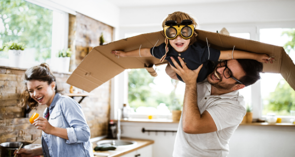 Dad holding son in the air while he pretends to be an airplane