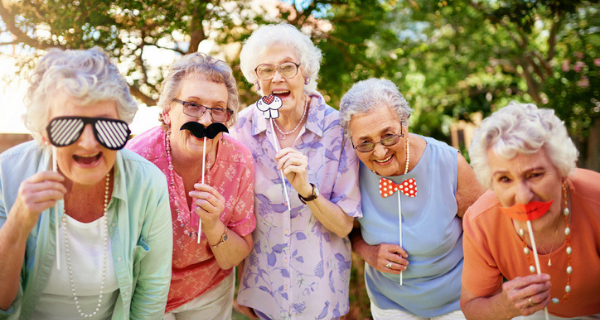 group of happy seniors with photobooth props