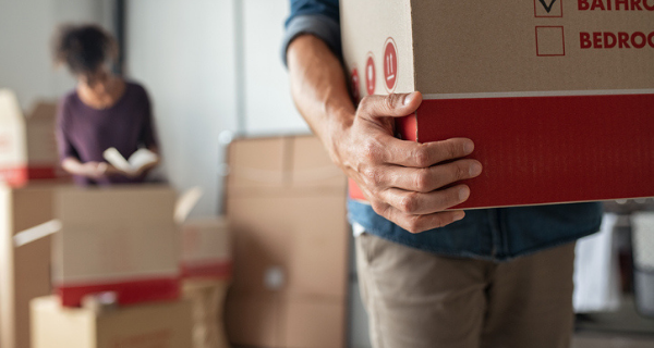 Detail shot of someone carrying a moving box.