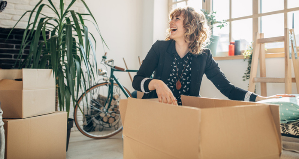 Woman packing belongings into box.