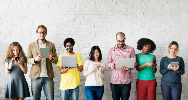 Image of people standing in a line and using technology