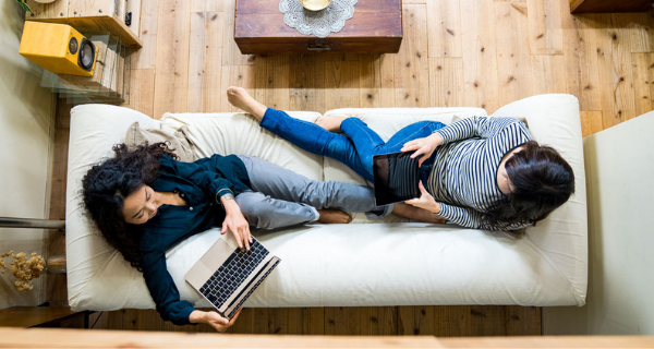 Renters on a couch on their computer.