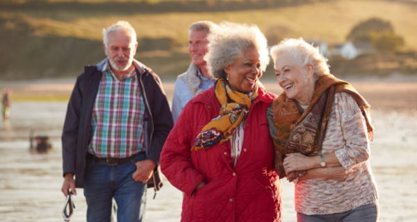 Seniors walking on the beach in the wind.