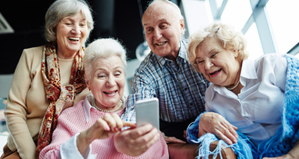 Image of a group of seniors looking at a mobile phone.