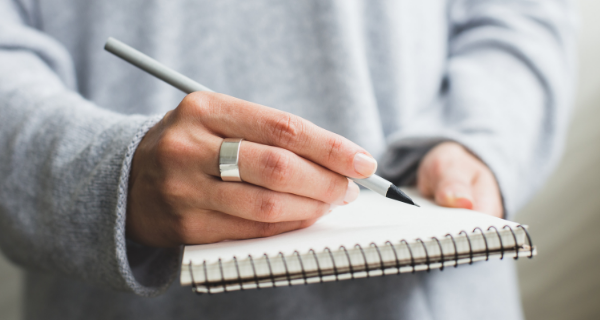 Image of person writing in notebook.